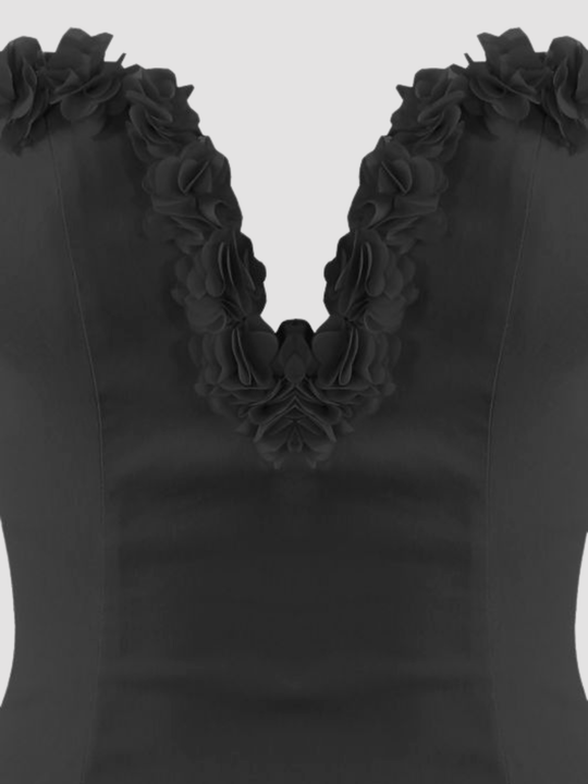 Close up. Ghost mannequin stands in front of plain background. The ghost mannequin wears a black sleeveless bodycon dress,  with a deep V-neckline and 3D rose ruffled trim.  The dress demonstrates a close up of the 3D rose trim sweetheart neckline design.