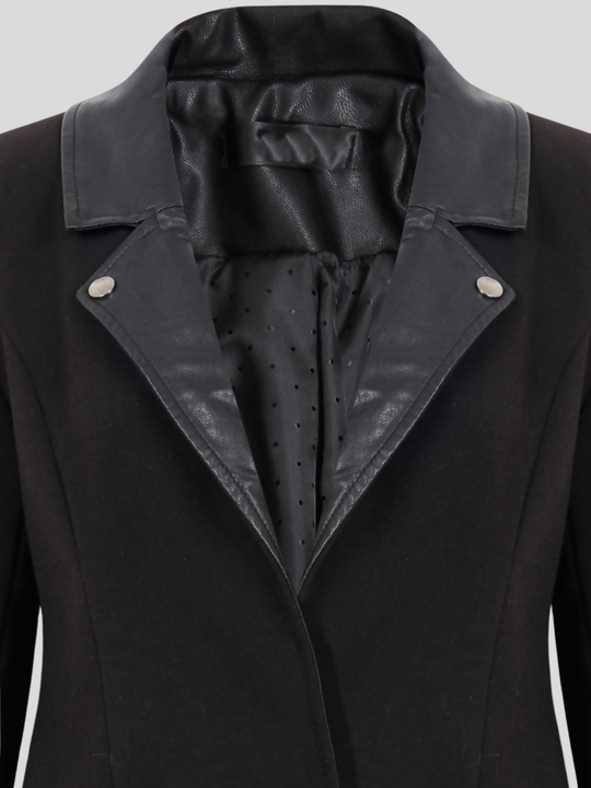 Close up. Ghost mannequin wears a  single breasted black tailored blazer, with faux leather lapel and single front button fasten. The faux leather lapel is visible. 