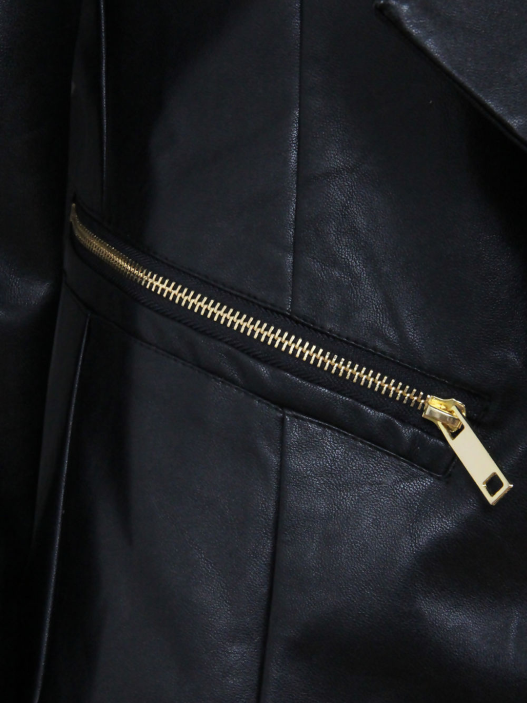 Close up of  black water fall jacket, with gold exposed side zip design. 