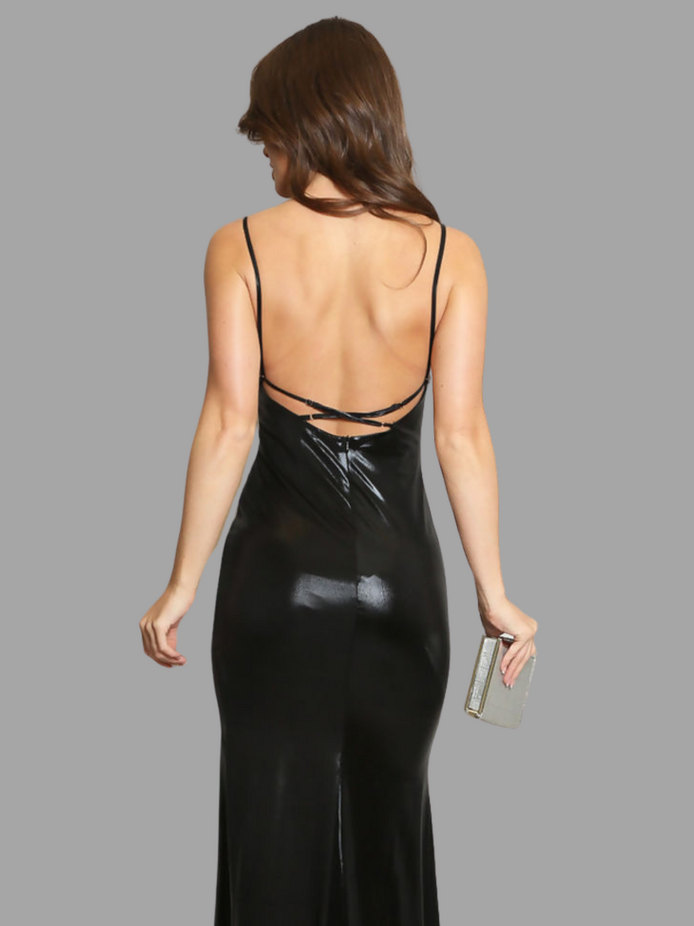 Model wears a black metallic cowl neck maxi dress, with a  Low back and a thigh high side split. The model has tanned skin and brown hair, she stands with her back to the camera, the low back of the dress can be seen, including the adjustable straps. 
