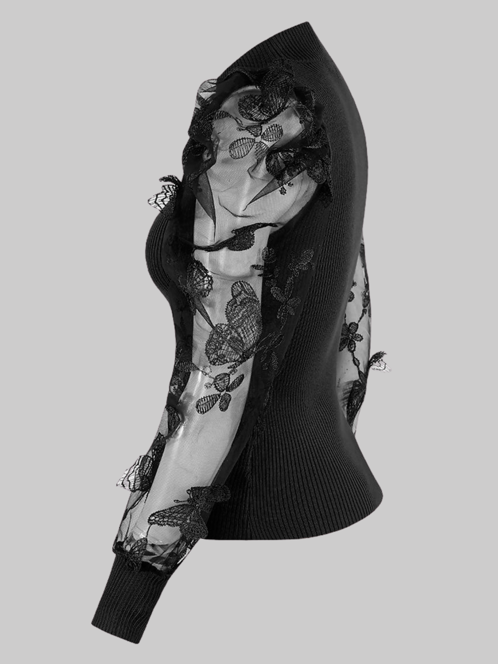 Ghost mannequin wears a black high neck jumper, with sheer sleeves and an embroidery crocheted design.  The ghost mannequin stands to the side, the side of the jumper can be seen, the sheer sleeves and the intricate embroidery can be seen. 