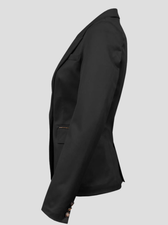 Ghost mannequin wears a black double breasted blazer with single button fastening, with long sleeves, faux pockets that have an exposed zip detailing and black and gold button detailing. The ghost mannequin stands to the side, the side of the blazer can be seen,including the gold and black button sleeves and gold zipper detailing design can be seen.