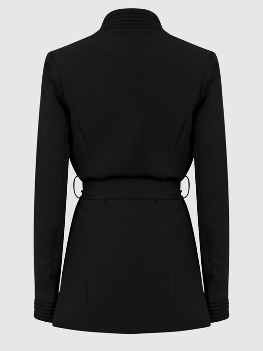 Ghost mannequin stands in front of a plain light grey background. The ghost mannequin  wears a black wrap coat, with a belted waist fastening, the coat has long sleeves. The ghost mannequin stands with its back to the camera, the back of the coat and the back can be seen. 