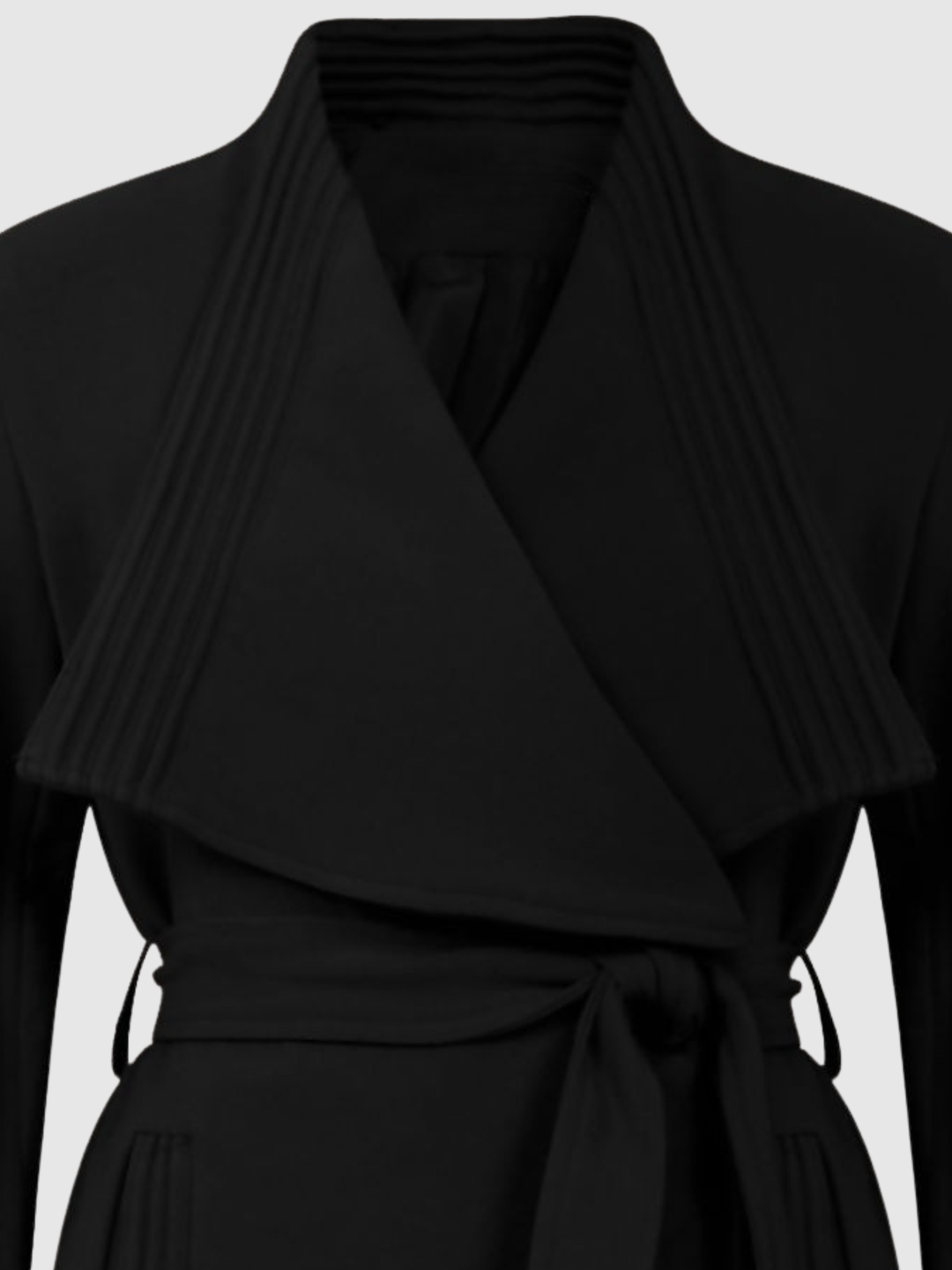 Mid Shot. Ghost mannequin stands in front of a plain light grey background. The ghost mannequin  wears a black wrap coat, with a belted waist fastening. The top of the coat can be seen, including the wrap front.