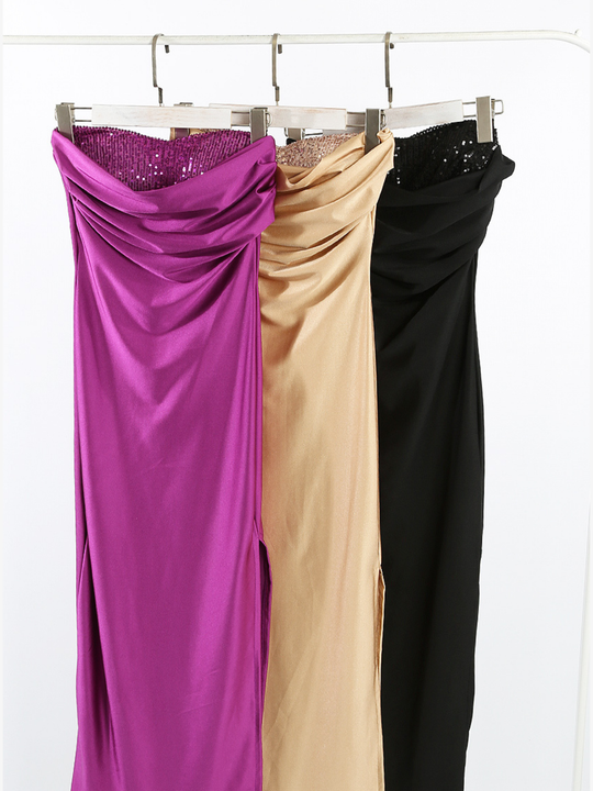 Clothes rail showing fuschia pink, beige and black maxi dresses with sequined inserts. 