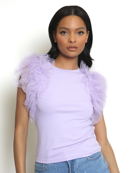 Woman wearing a light purple top with ruffled sleeves against a white background. The lilac t shirt has a rounded neck and the frill organza sleeves are short. The model has light brown skin and long black hair, she faces forward, looking directly into the camera with her hands by her sides. 