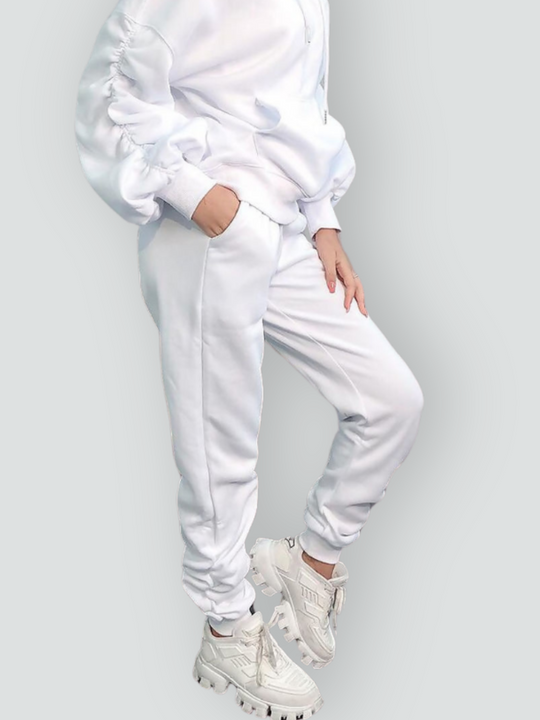 Model wears a ruched sleeve hooded jumper which has an adjustable hooded draw string  tightening if required. The hood comes with a matching white joggers that has a ruched design at the ankles. The torso of the jumper and legs of the joggers can be seen, including the ruched sleeve and  ruched ankle design. 