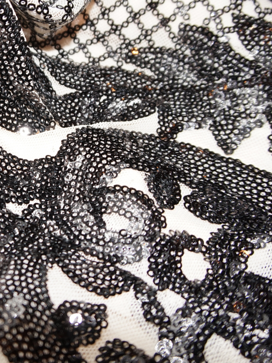  Closeup of the cream and black sequined material. 