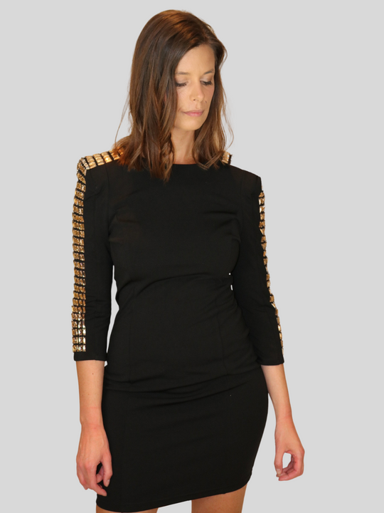 4ever Stunning Deluxe Premium black midi dress with gold rhinestone jeweled arms and chunky gold back zip fastening. Model looks down on the floor and has her hands by her sides.