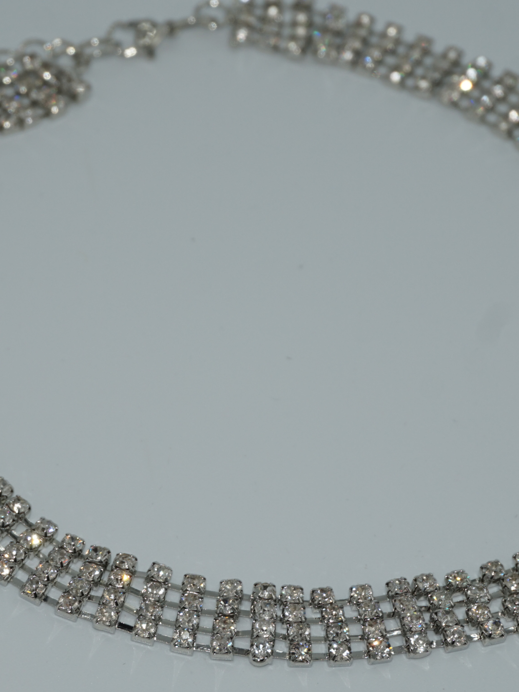 Close up of the silver diamante choker with interconnected links. 