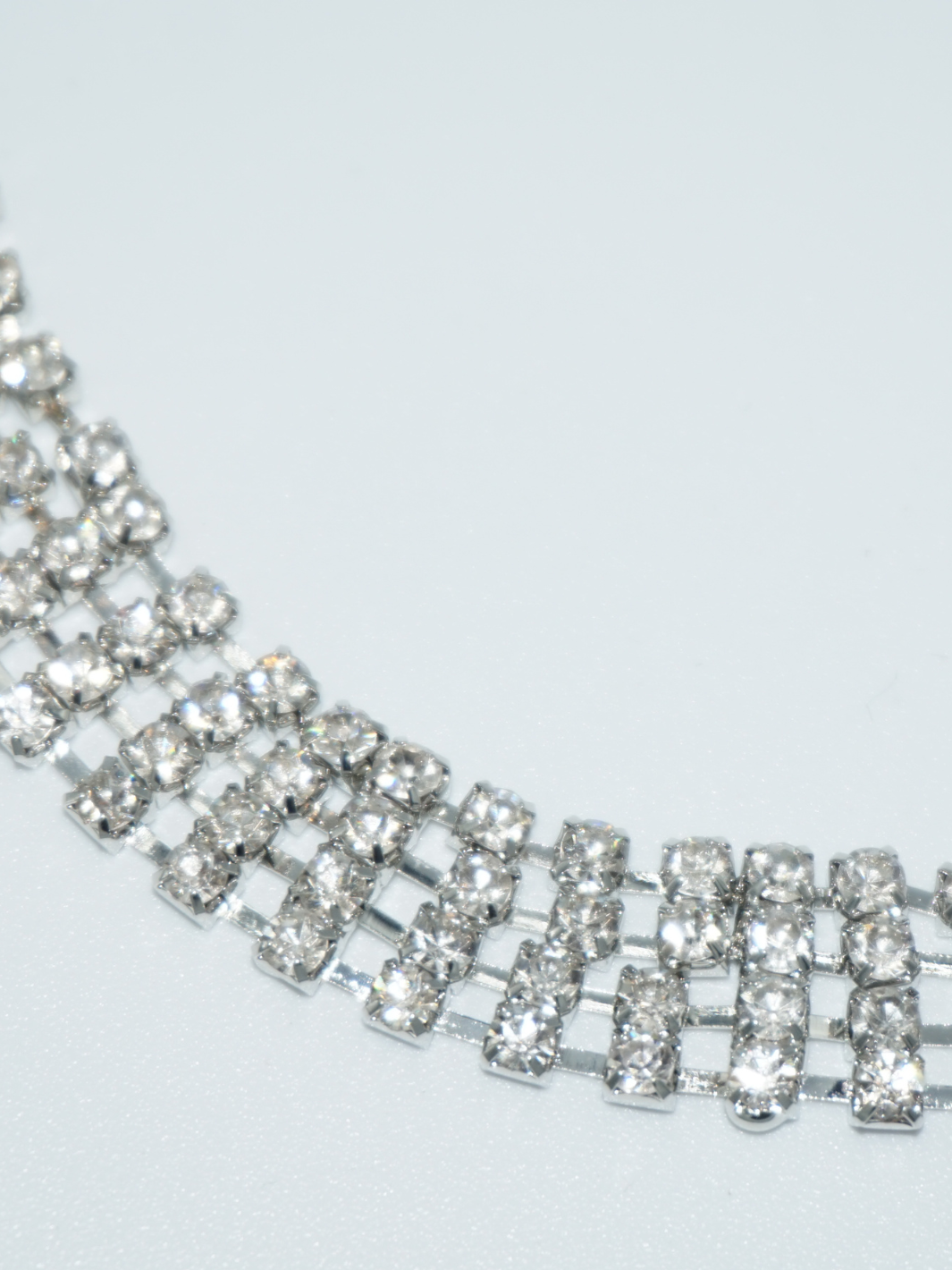 Close up of a silver diamante choker, the links are visible. 