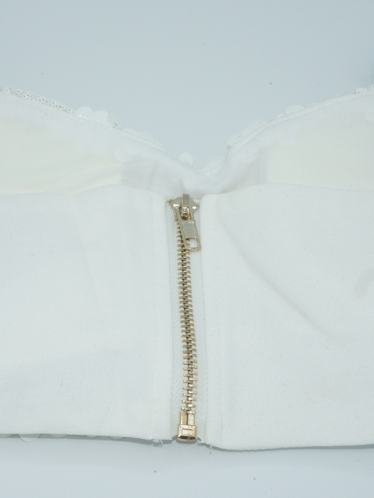 close up of tghe back of the sequined bralette. The rear chunky zip fastening is present.
