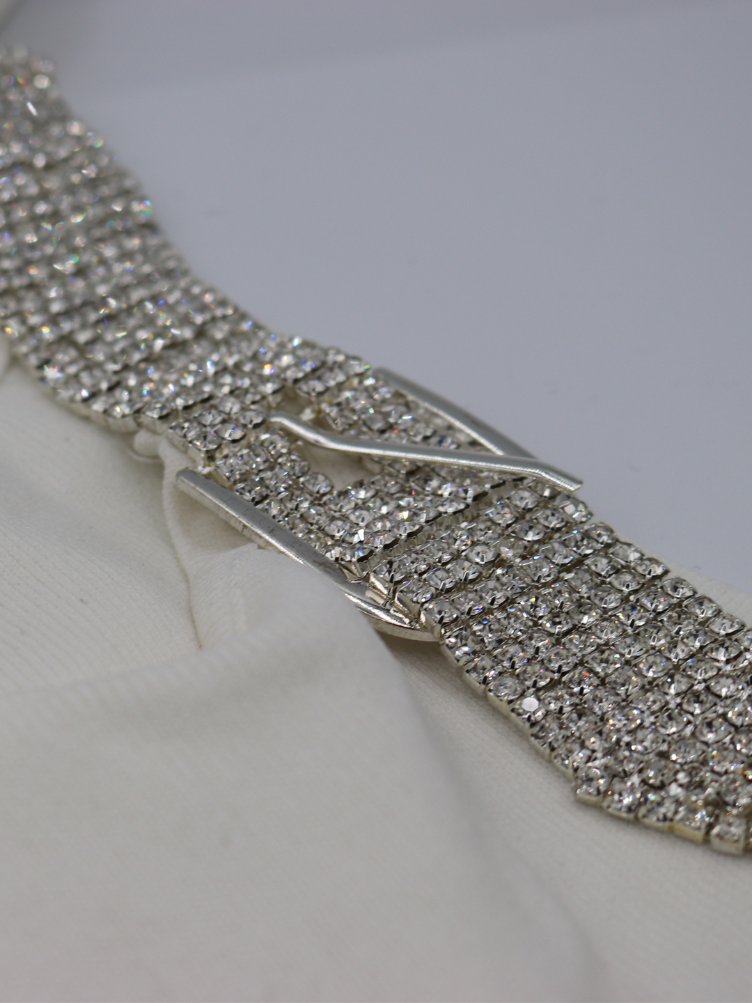 Closeup photograph of the diamante strap on the ribbed  cream mini dress. 