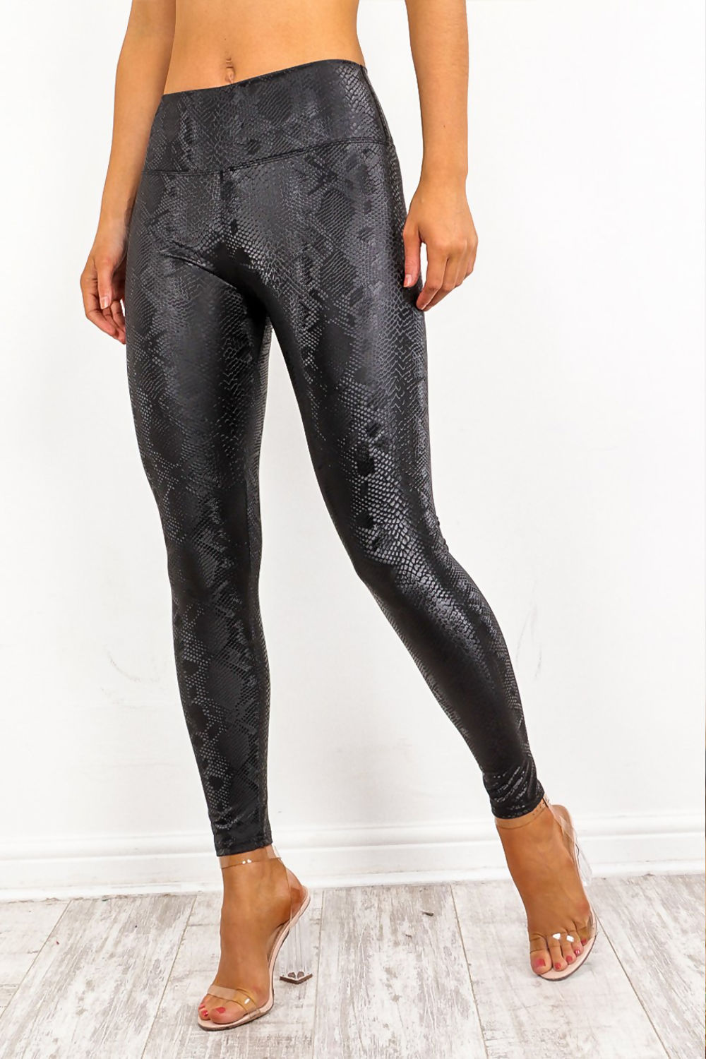Model wears snake skin leggings with high waisted panelling. Model stands to the side. The snake skin pattern is visisble. 