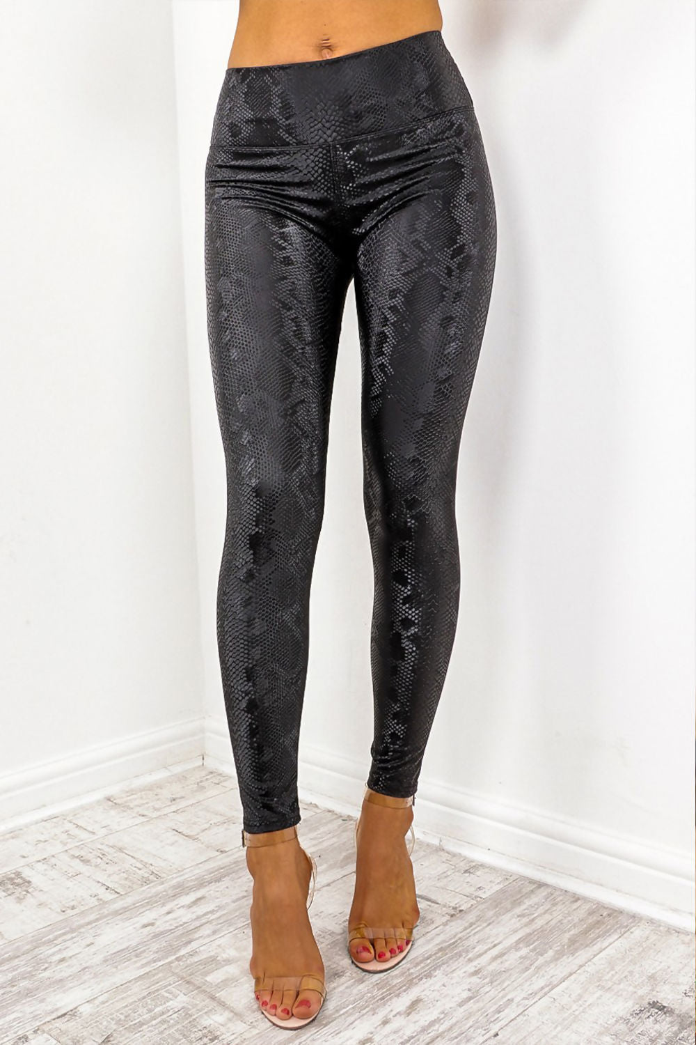 Model wears snake skin leggings with high waisted panelling. The snake skin pattern is visisble. Models stands facing the camera with her legs slightly apart. 