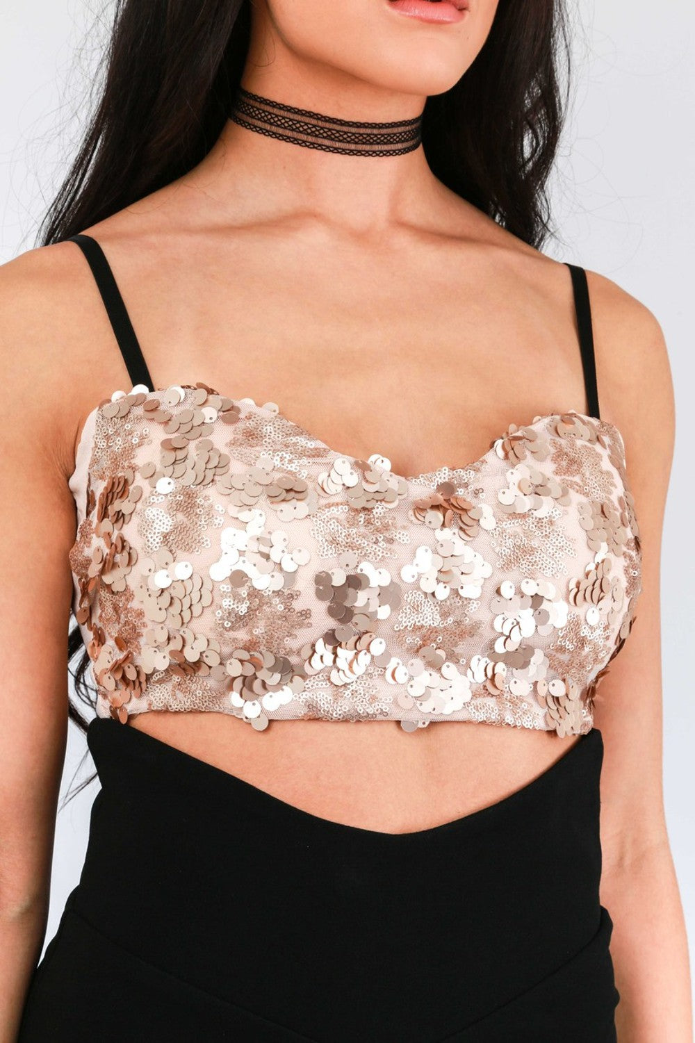 Model wears pink sequined bralette with  thin black strap and chunky back zip fastening. Model wears a black skirt and a black choker.
