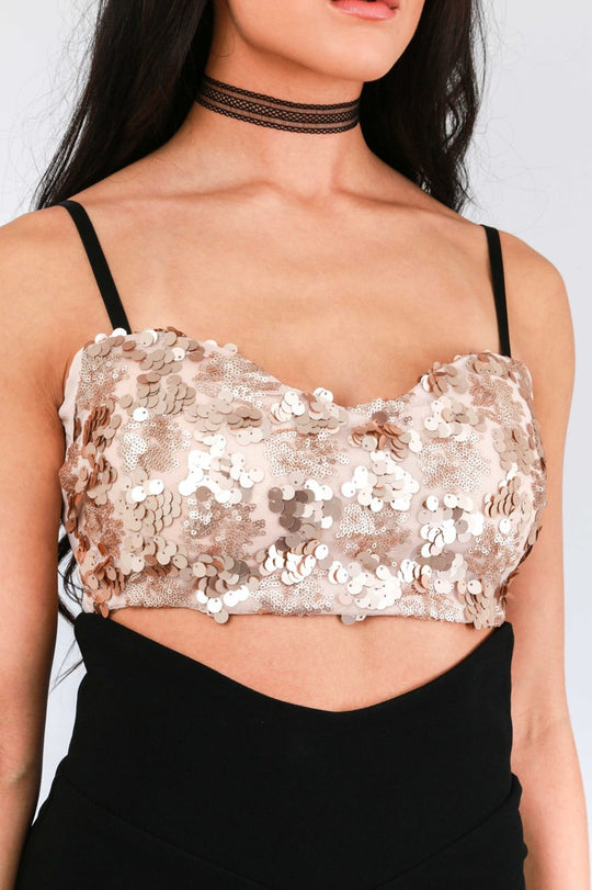 Model wears pink sequined bralette with  thin black strap and chunky back zip fastening. Model wears a black skirt and a black choker.