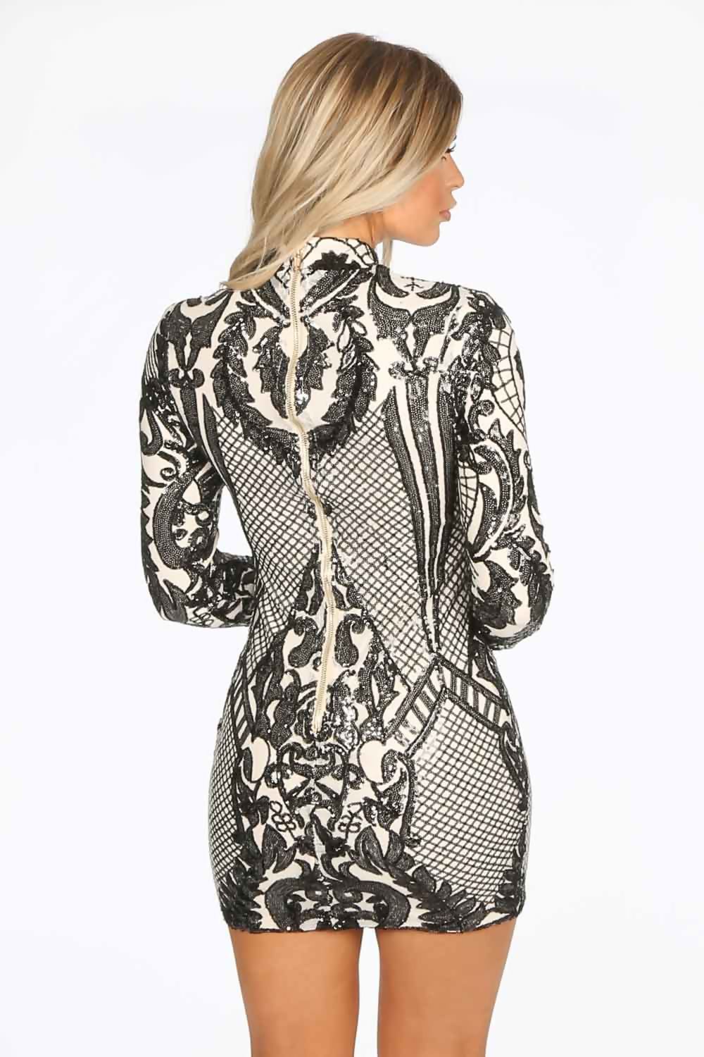 Model wears 4ever stunning premium deluxe a sequined  cream and black long sleeved dress, with a high neck and chunky gold back zip fastening.  Model has her back to the camera and looks to the side. 