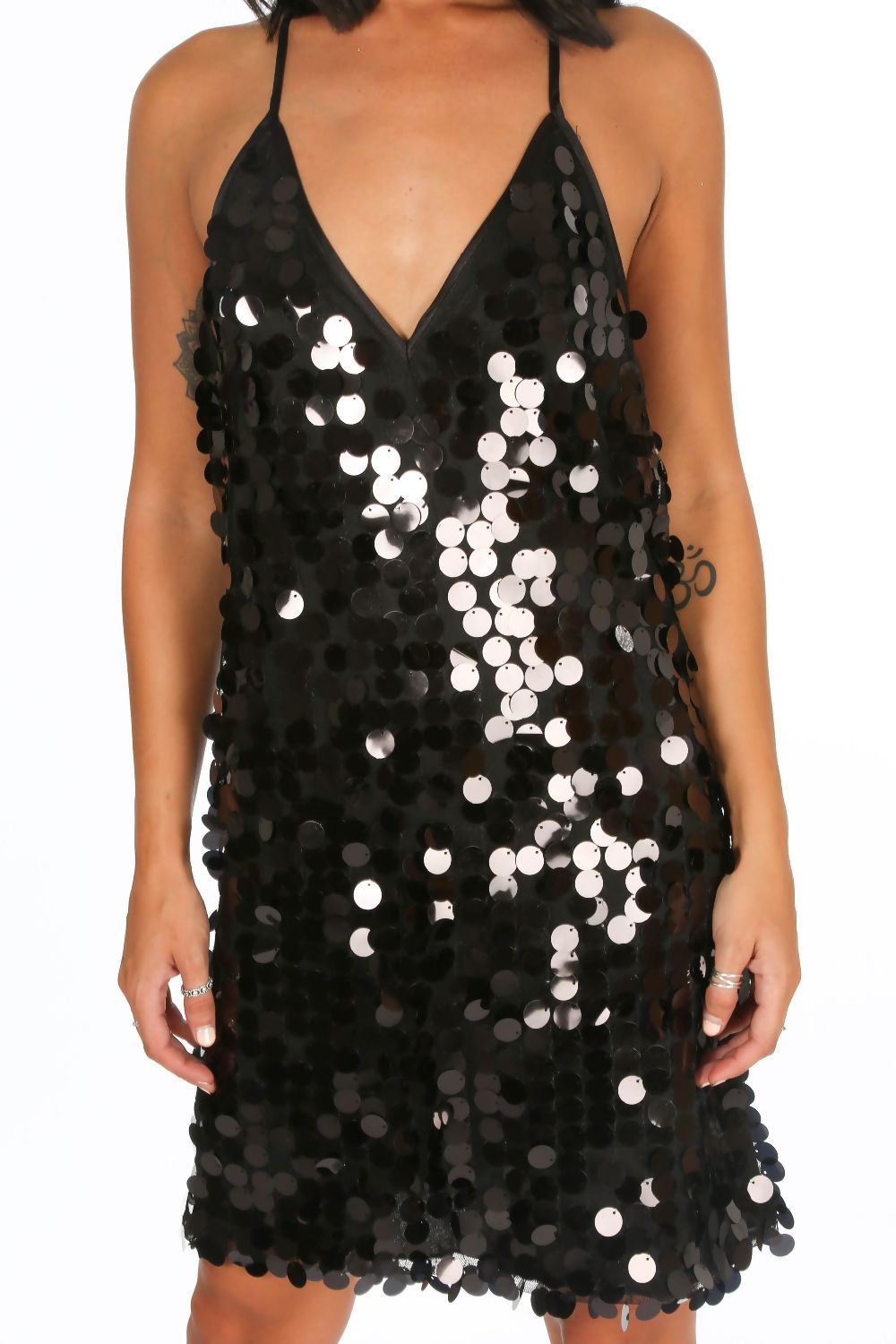Model wears a shift dress with large sequin circled detailing. The dress has a plunging neckline and spaghetti detailing with an open back. Model stands facing the camera with her hands by her side. There is a close up of the dress with large sequin detailing evident. 