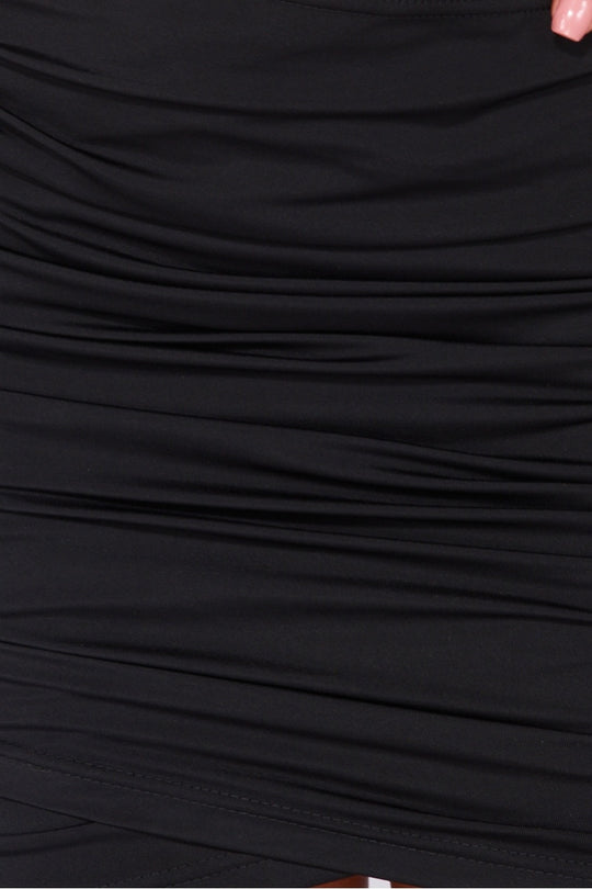 Black slinky bodycon dress with cut out mid section with cross over straps. The dress has a multiway function, you can wear it as a halter neck cross strap or as a standard halterneck. Model wears the halterneck as a cross neck halter. The picture shows a closeup of the slinky material. 