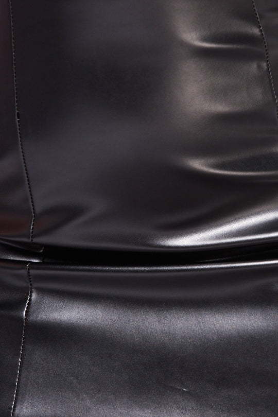 Close up of faux leather bandeau mini dress demonstrating the material. 