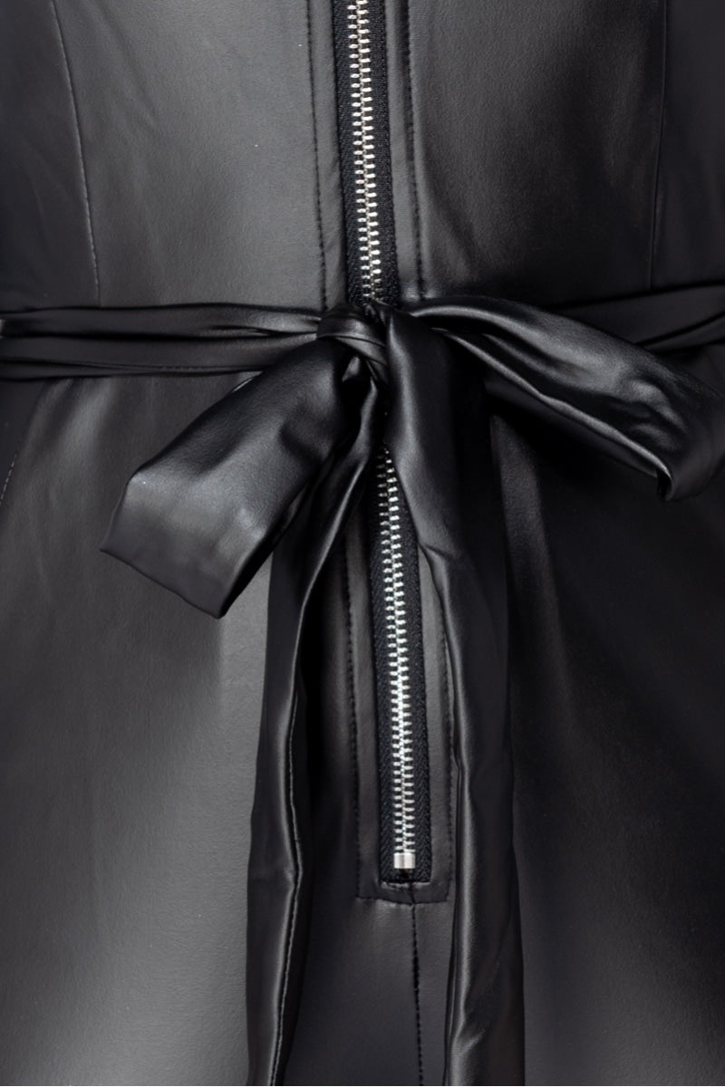  Faux leather black  jumpsuit that has long sleeves and front zip fastening. The picture shows a close up of the faux leather jumpsuit, demonstrating the silver zip fasetening and faux leather belt. 