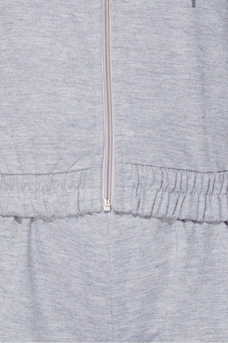Close up of the material of the  light weight tracksuit with front zip fastening and draws string hood. 