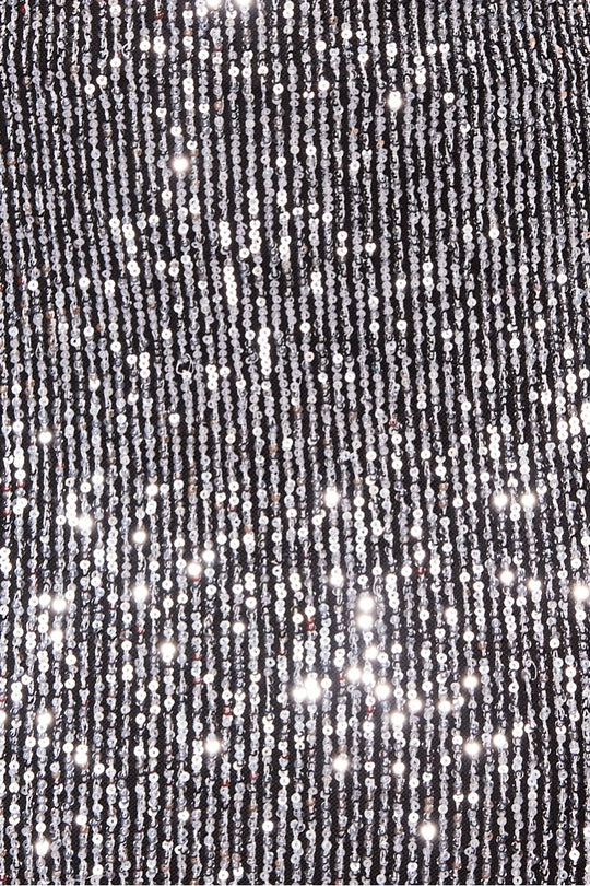 Close up of sequined material. The silver sequin and the black material is visible. 